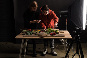 two photographers making food composition for commercial photography on smartphone