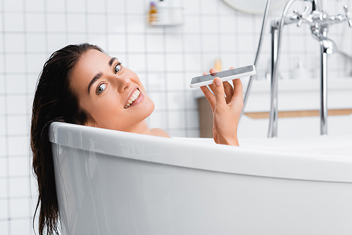 happy young woman  while taking bath and talking on mobile phone