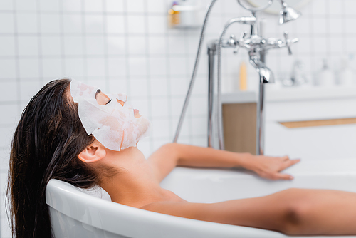 young woman in face mask taking bath at home