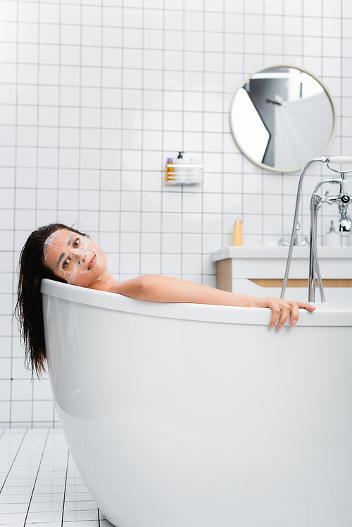 young woman in face mask taking bath and  at home