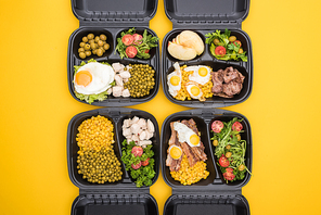 top view of  packages with apples, vegetables, meat, fried eggs and salads isolated on yellow