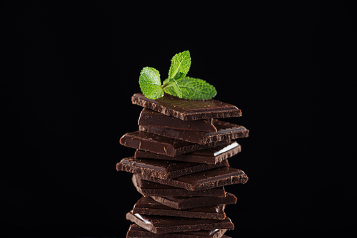 Dark chocolate stack with fresh mint, isolated on black