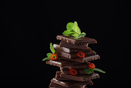Dark chocolate stack with fresh mint and chili, isolated on black