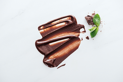 Top view of melted chocolate with pieces of chocolate and mint