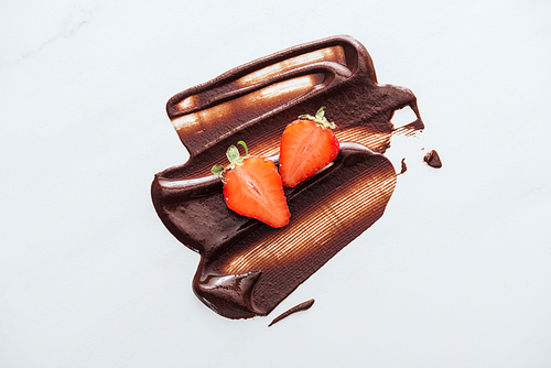 Top view of strawberries with liquid chocolate on white background