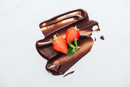 Top view of strawberries and fresh mint with liquid chocolate