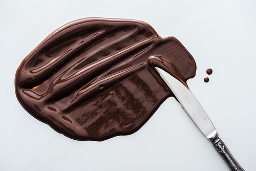 Top view of table knife with melted dark chocolate