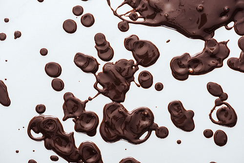 Top view of drops of liquid dark chocolate, abstract background