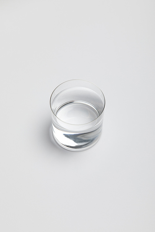 transparent glass of fresh water on white surface