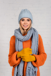 Young woman in warm hat, knitted sweater and gloves  on white background