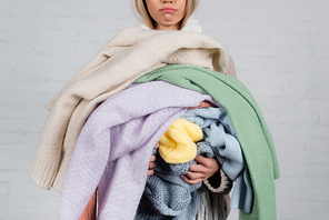 Cropped view of knitwear in hands of woman on white background