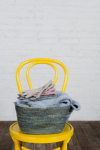 Basket with gloves and sweater on chair at home