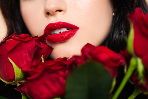 close up of young woman with near red roses