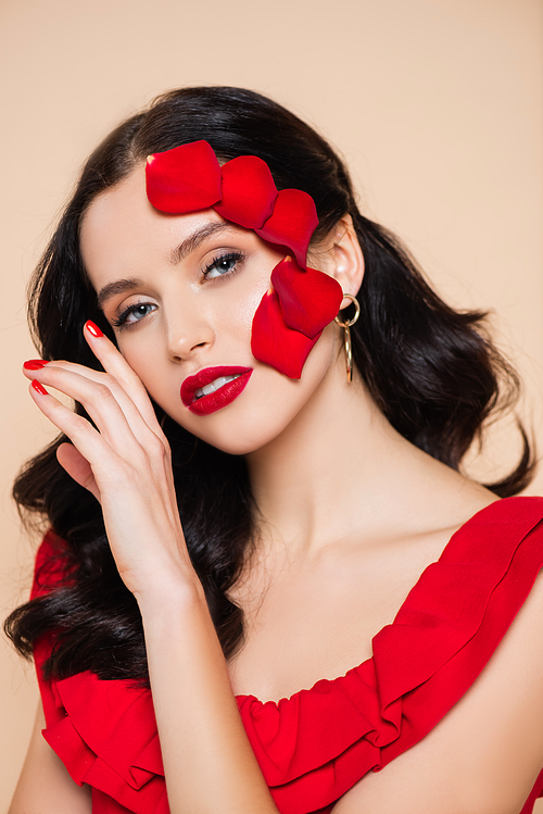 pretty young woman with petals of red rose on face isolated on pink
