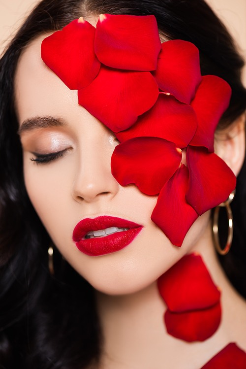 pretty young woman with closed eyes and rose petals on face