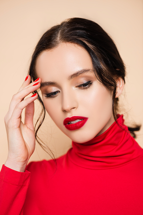 brunette young woman with red lips looking down isolated on pink