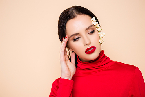 young woman with red lips and flowers on face looking away isolated on pink