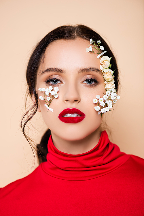 brunette woman with red lips and flowers on face  isolated on pink