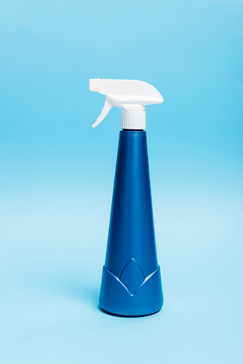 Bottle of detergent with sprayer on blue background