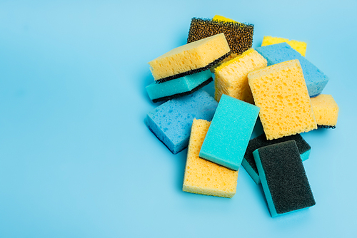 High angle view of yellow and blue sponges on blue background