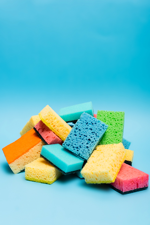 Pile of colorful sponges on blue background