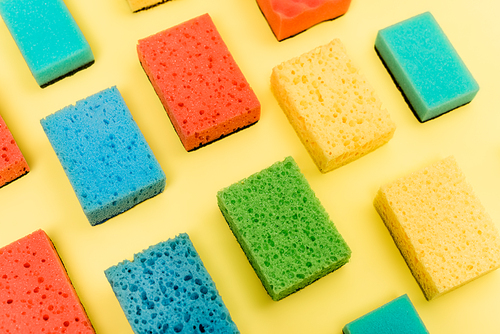 High angle view of colorful sponges on yellow background