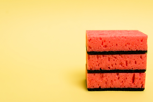 Close up view of pink sponges on yellow background