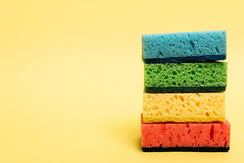 Close up view of colorful sponges on yellow background