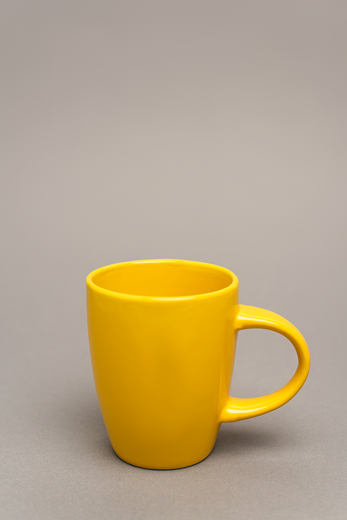 yellow mug with hot beverage on grey with copy space