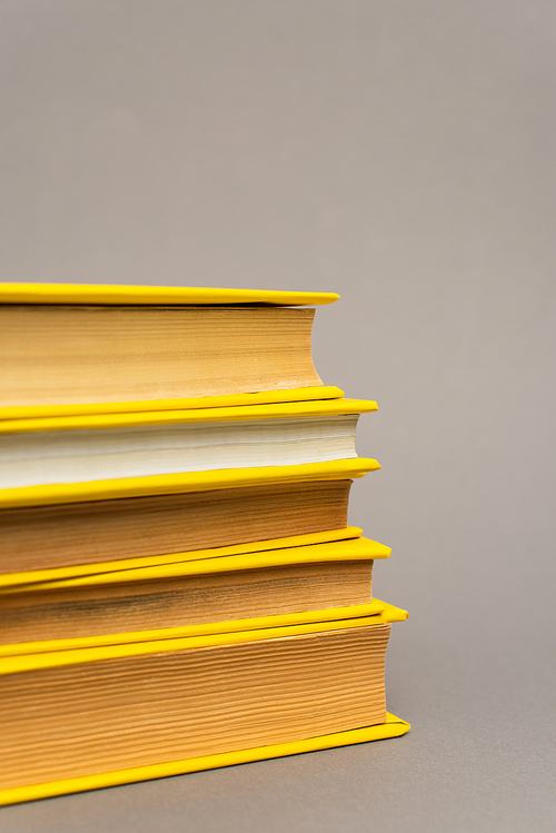 stack of yellow notebooks isolated on grey