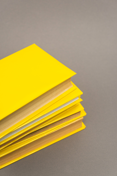 pile of yellow notebooks isolated on grey