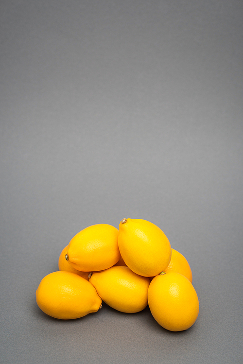 fresh and yellow lemons on grey background