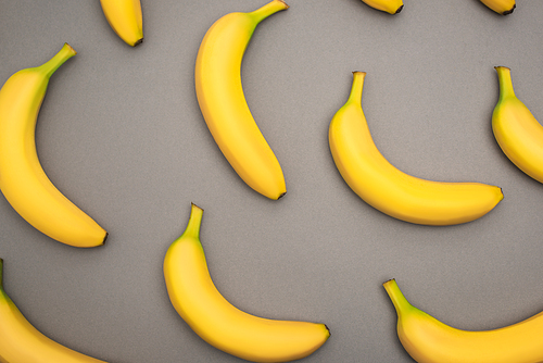 top view of ripe yellow bananas on grey background