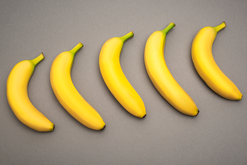 top view of yellow fresh bananas on grey background