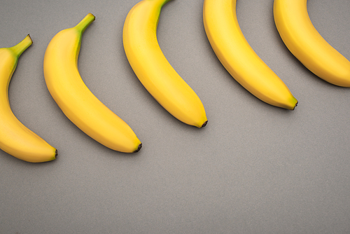 top view of yellow ripe bananas on grey background