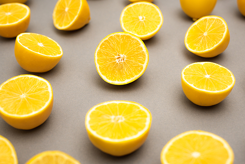 row of fresh and ripe lemons halves on grey