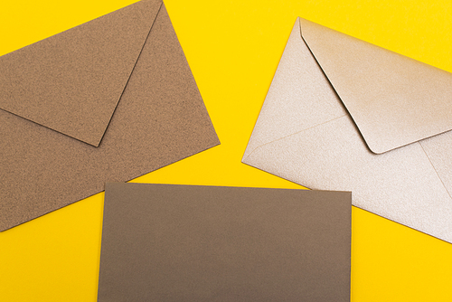 top view of paper envelopes isolated on yellow