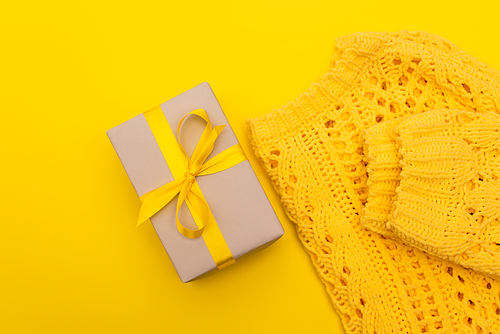 top view of wrapped present near jumper isolated on yellow
