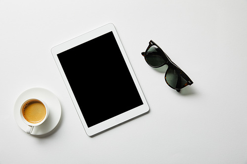 top view of digital tablet, coffee and glasses on white surface