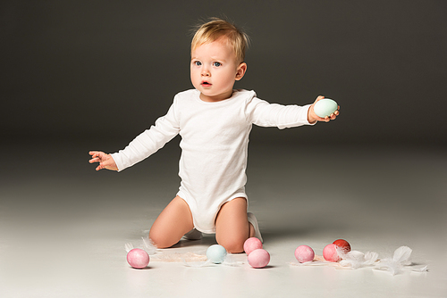 cute child outstretching hands, holding . eggs on black background