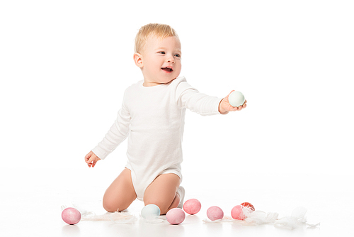child next to . eggs and feathers on white background