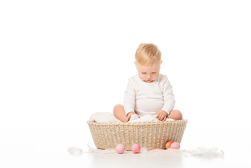 child with lowered head on blanket in basket with . eggs around on white background