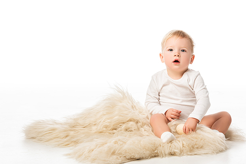Cute child  with open mouth and sitting on fur on white background