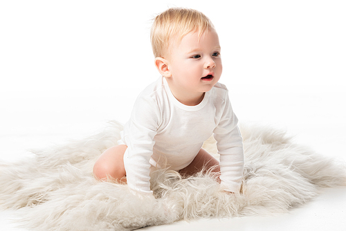 Cute child on all fours on fur on white background