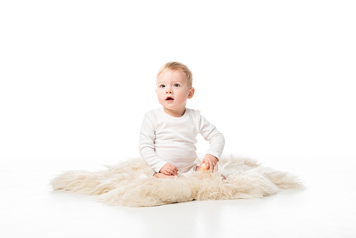 Cute kid with open mouth sitting on fur on white background