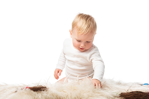 Child looking down, sitting on fur with nests isolated on white