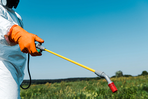 cropped view of exterminator in uniform holding spray outside