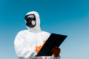 man in protective mask and uniform holding clipboard