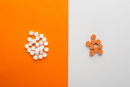 Top view of pills on white and orange background