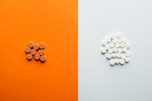 Top view of medicines on white and orange background